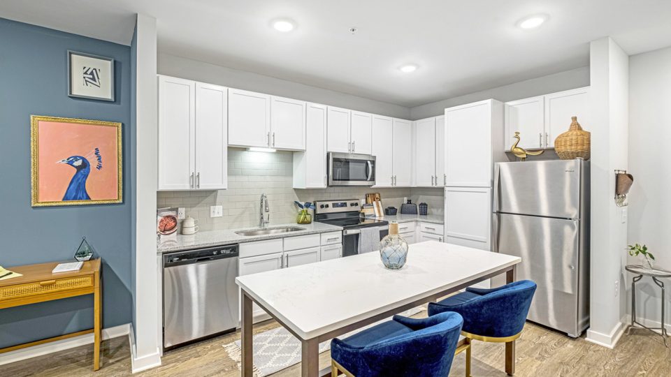 a kitchen with blue chairs and a white table at The Novo Sweetwater